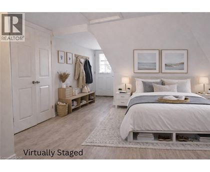 A bedroom with a bed, nightstands, and a coat rack.