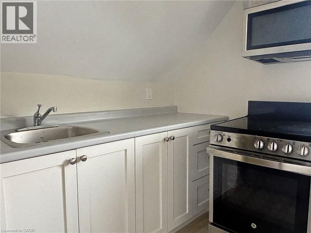 A kitchen with white cabinets and a black stove top oven.