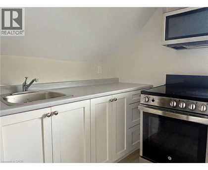 A kitchen with white cabinets and a black stove top oven.