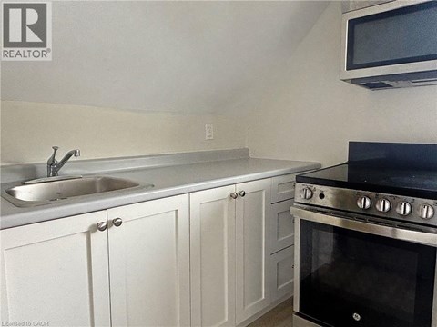 A kitchen with white cabinets and a black stove top oven.
