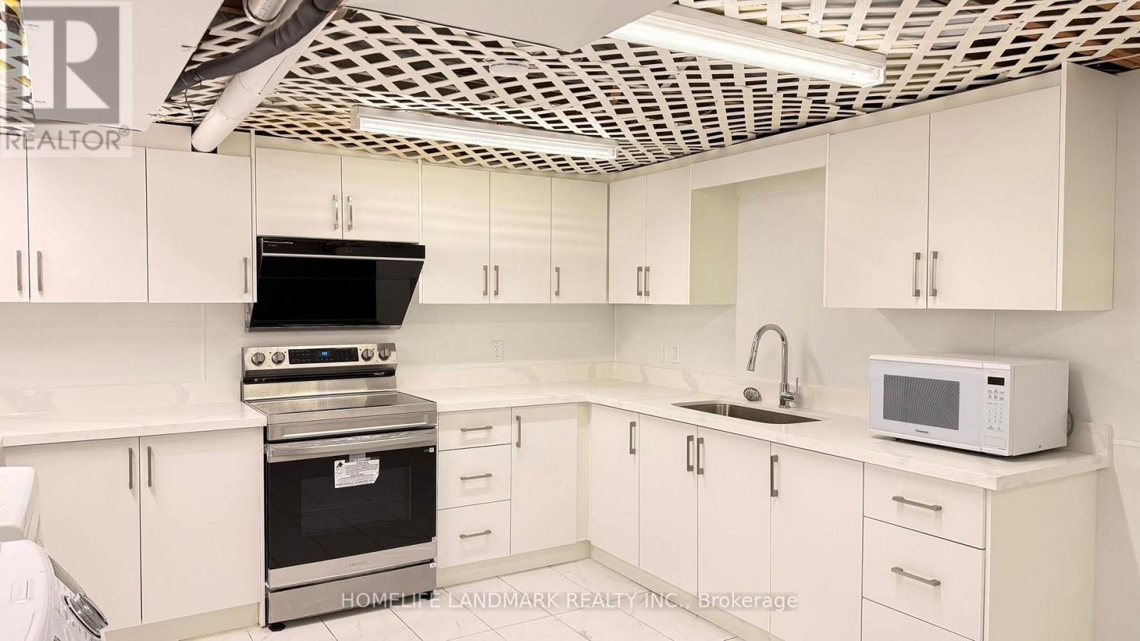 A kitchen with white cabinets and a black stove top oven.
