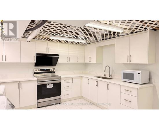 A kitchen with white cabinets and a black stove top oven.
