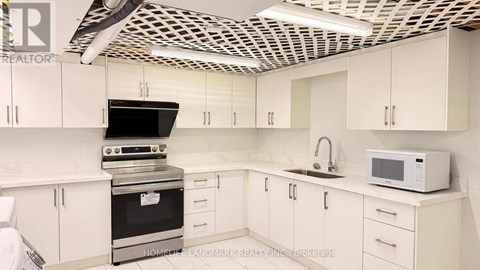 A kitchen with white cabinets and a black stove top oven.