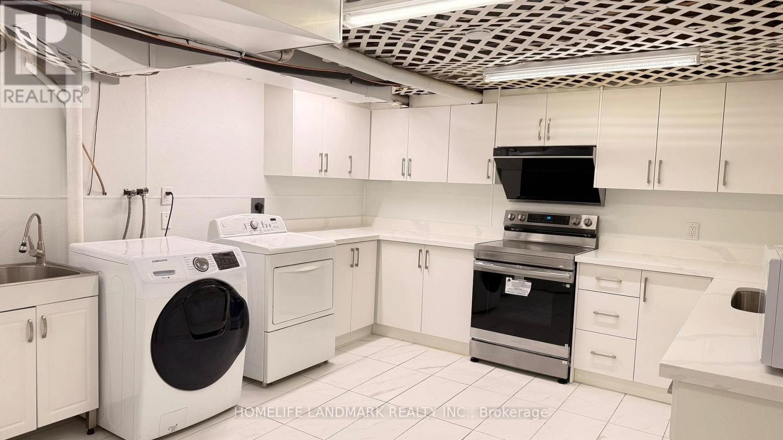 A modern kitchen with white appliances and cabinets.