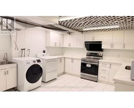 A modern kitchen with white appliances and cabinets.