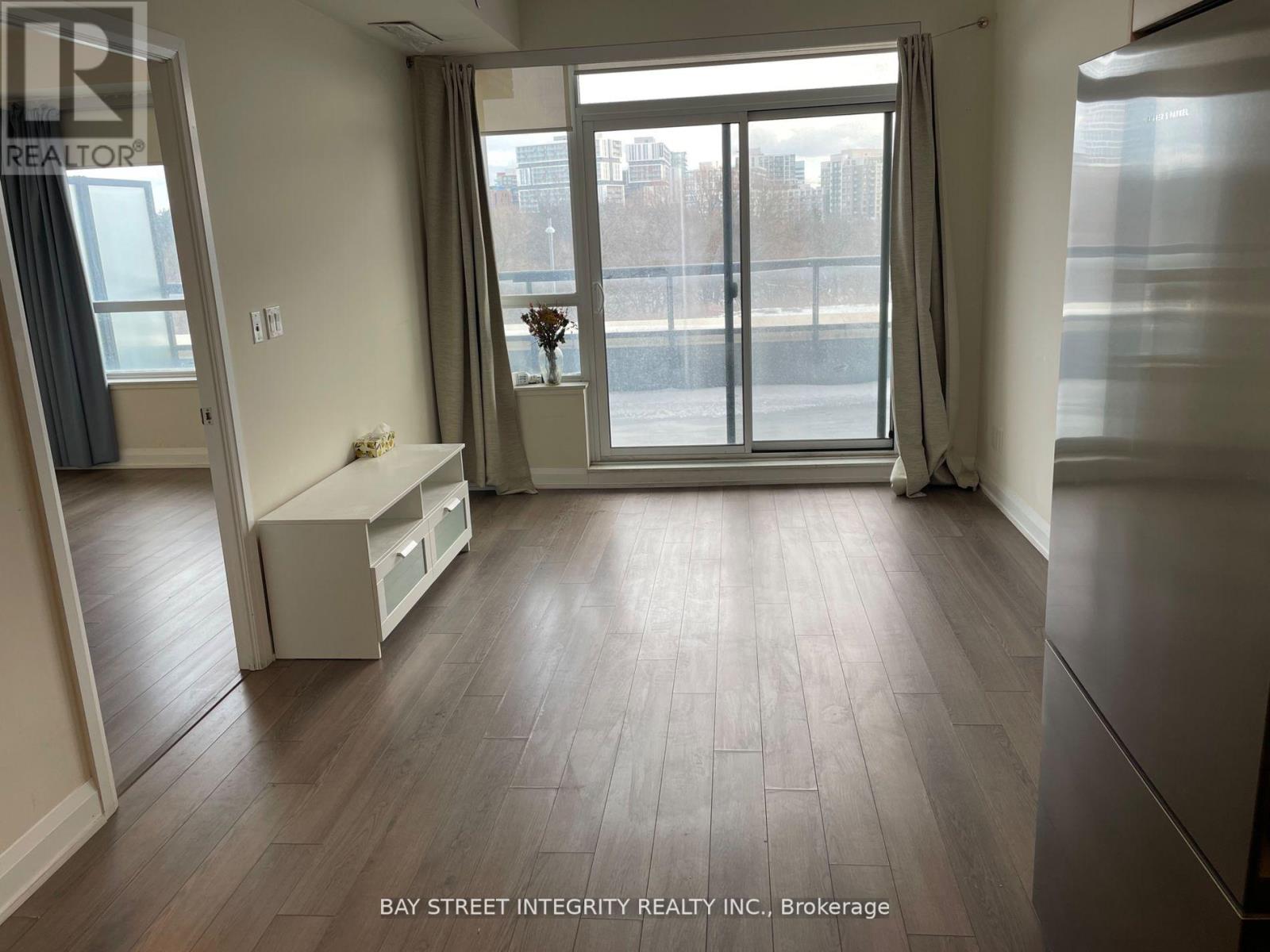 A spacious room with a large window and a view of the city.