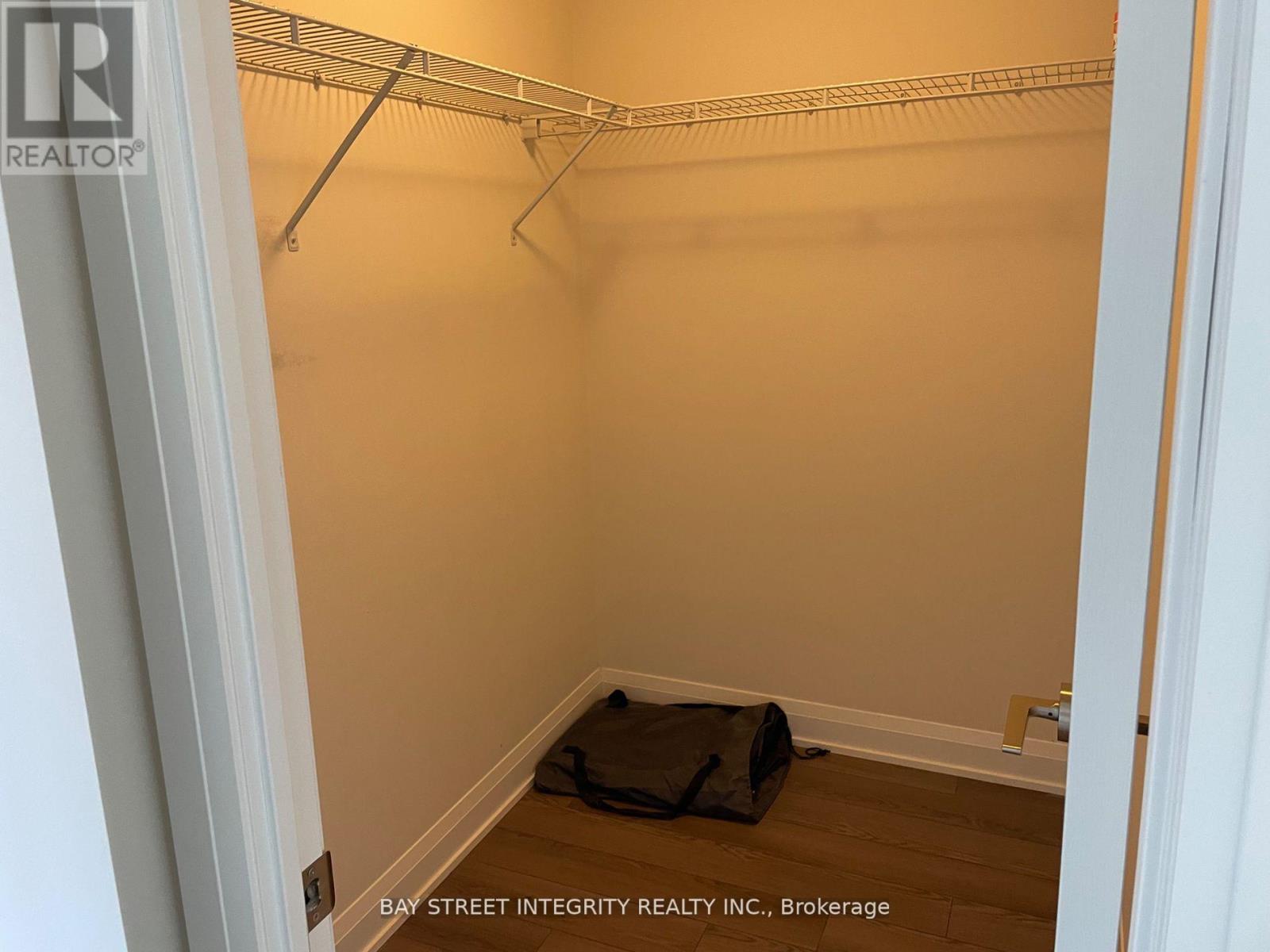 A room with a white wall and a black bag on the floor.