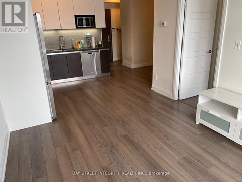 A kitchen with a refrigerator, microwave, and sink.
