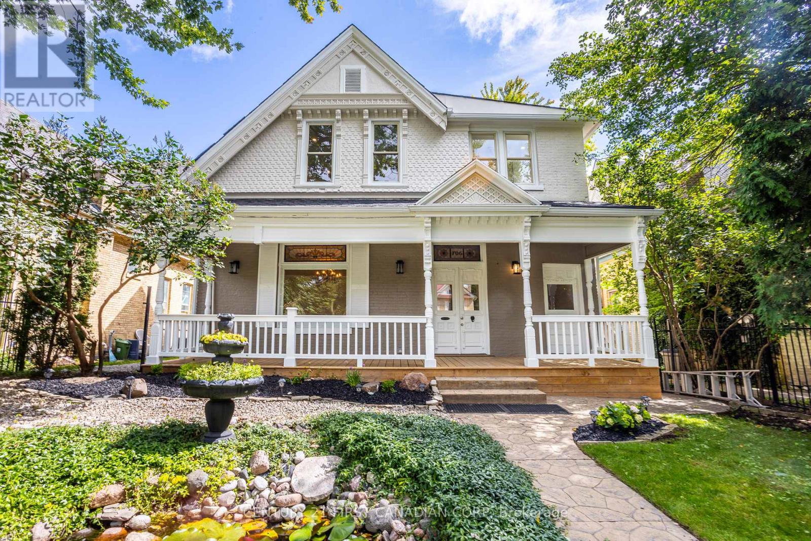 A white house with a front porch and a garden.