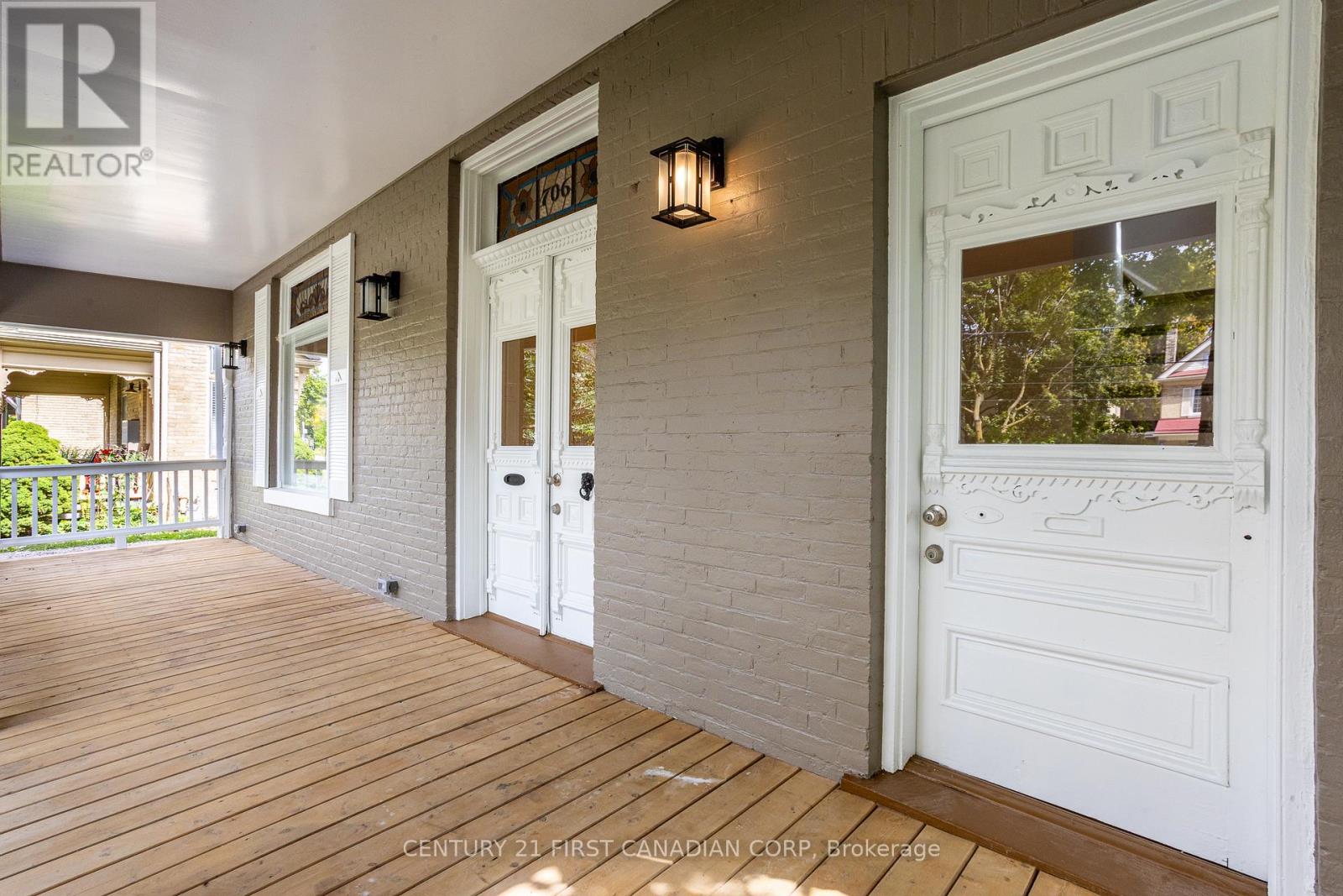 A porch with a white door and a sign that says REALTOR.