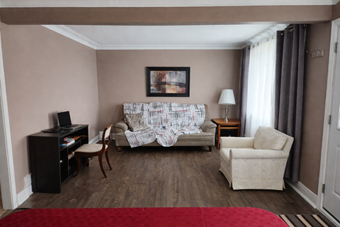 A living room with a couch, chair, and television.