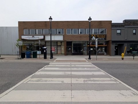 A street view of a crosswalk with a building in the background.