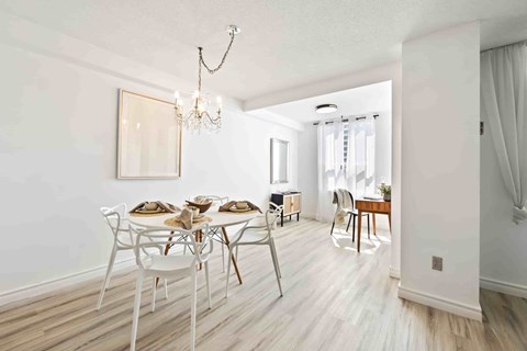 A dining room with a white table and chairs.