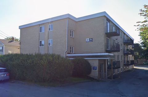 Apartment building with a car parked in front.