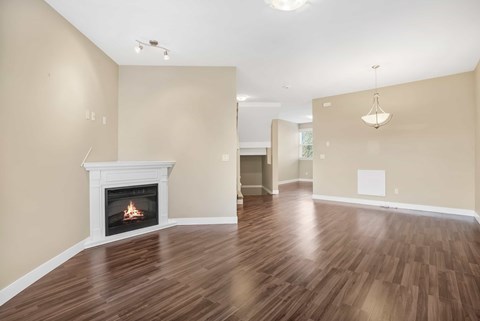A living room with a fireplace and wood flooring.