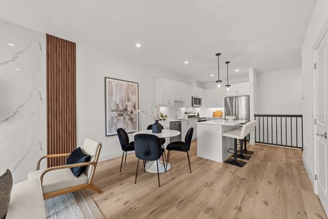 A modern dining room with a marble wall and a wooden floor.
