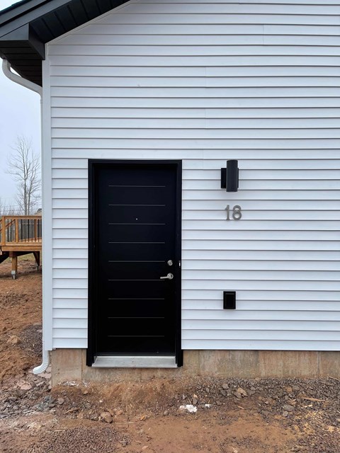 A black door with the number 18 on the wall above it.