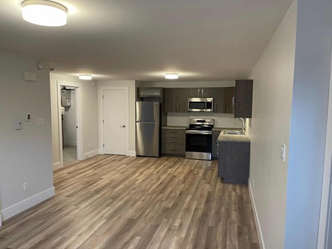 A kitchen with a refrigerator, oven, and microwave.