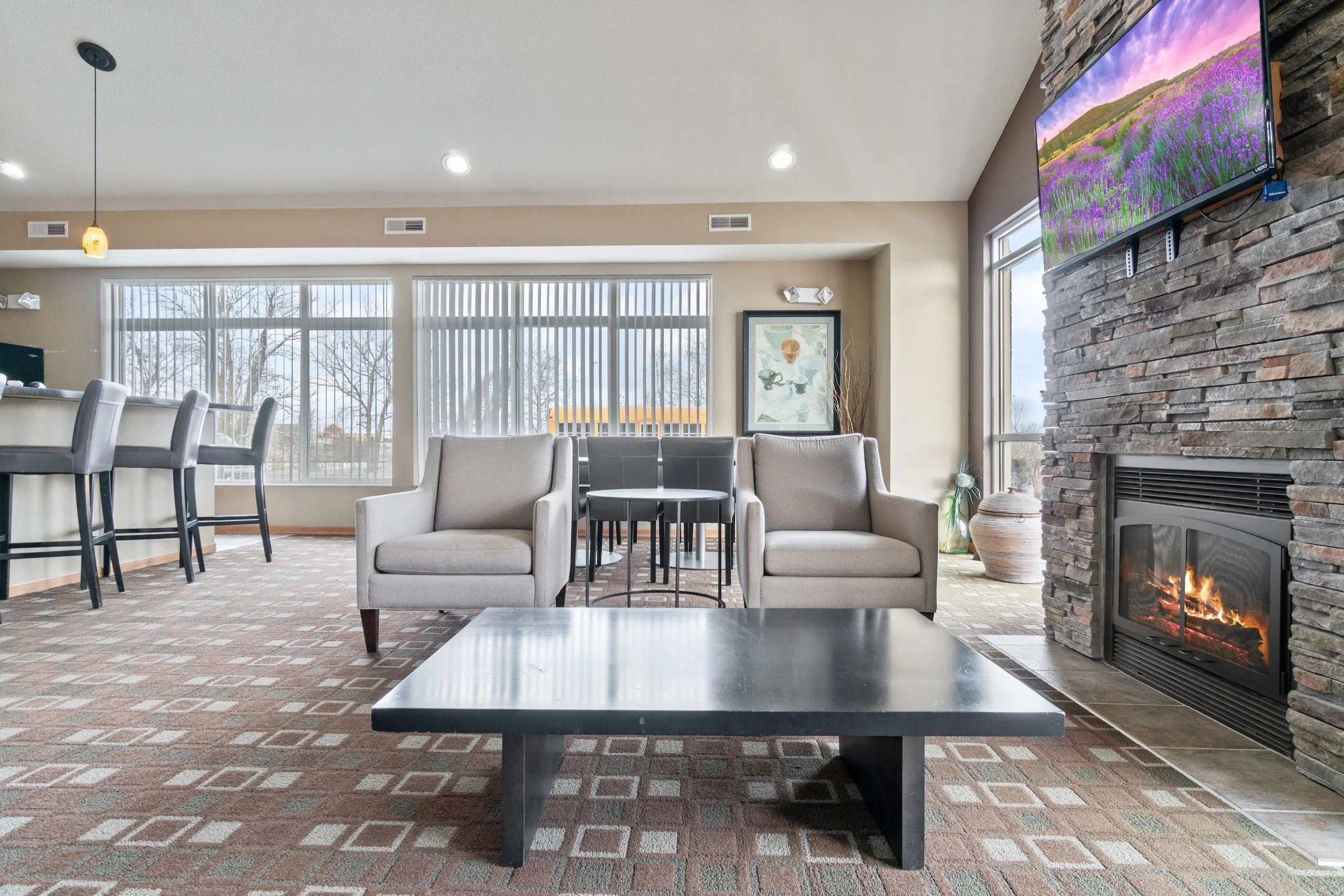 A modern living room with a fireplace and a flat screen TV mounted on the wall.