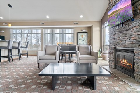 A modern living room with a fireplace and a flat screen TV mounted on the wall.