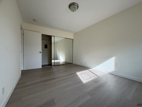 A room with a wooden floor and a white ceiling with a light fixture.