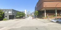 A street with a car and buildings on both sides.