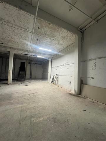 A large empty room with a concrete floor and walls.