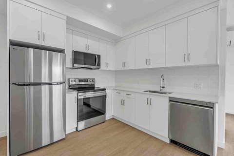 A kitchen with white cabinets and stainless steel appliances.