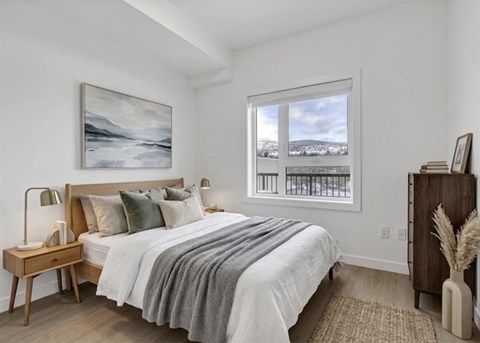 A bedroom with a large bed and a painting on the wall.