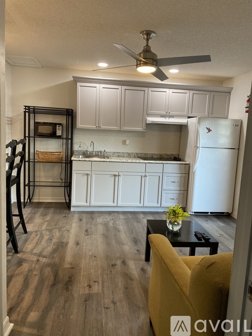 A kitchen with white cabinets and a white refrigerator.