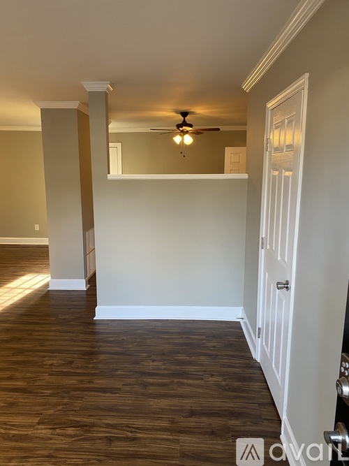A room with a wooden floor and a ceiling fan.