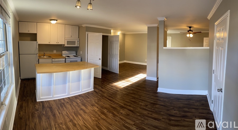A kitchen with a wooden floor and white walls.