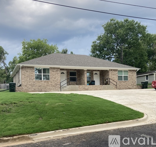 A house with a grey roof and a green lawn in front.