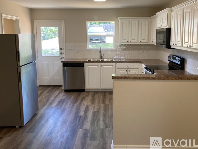 A kitchen with a refrigerator, sink, and stove.