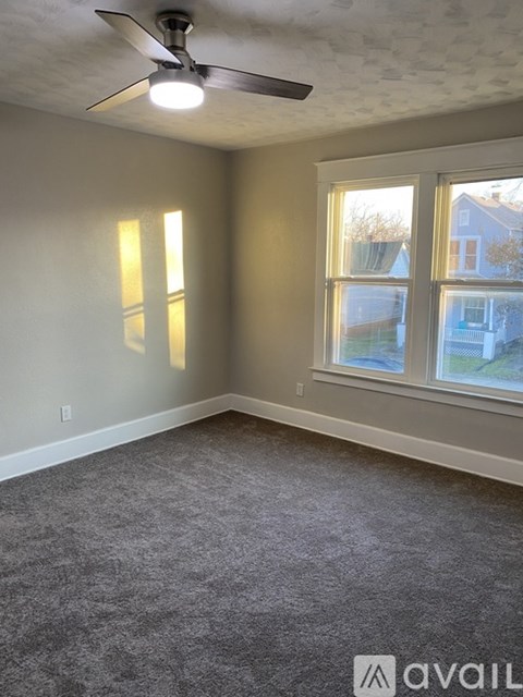 A room with a ceiling fan and a window.