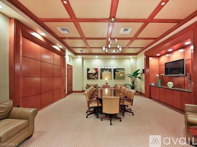 A conference room with a long table surrounded by chairs.