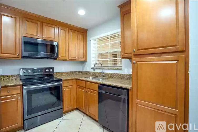 A kitchen with wooden cabinets and black appliances.