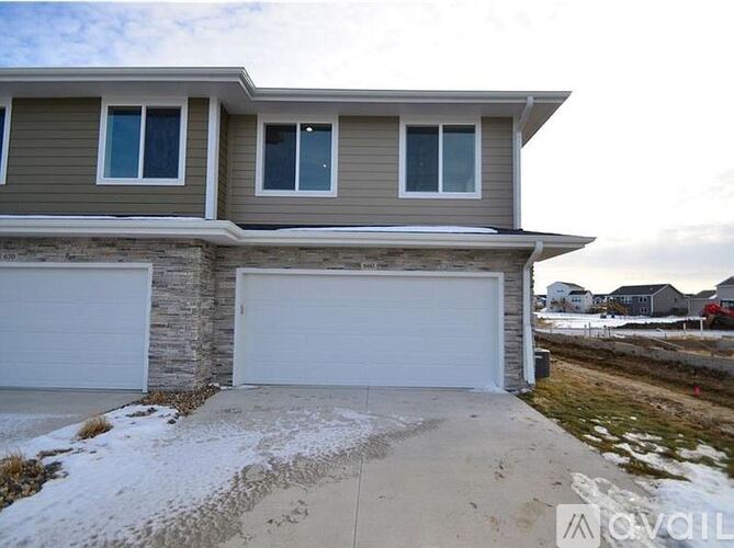 A house with a grey garage door and a brown wall.