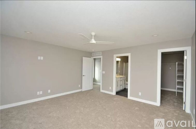 A spacious room with a fan on the ceiling and a ladder on the right side.
