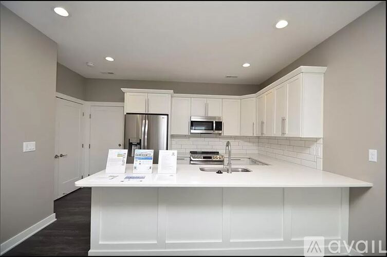 A kitchen with white cabinets and appliances is on the market.