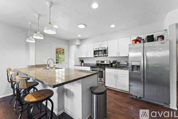 A kitchen with a granite countertop and stainless steel appliances.