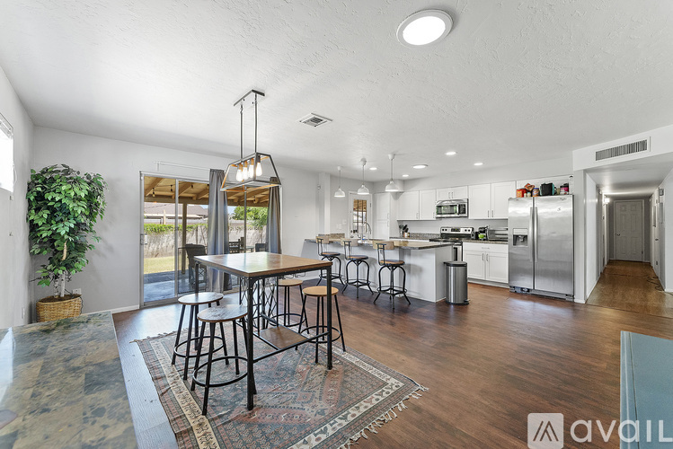 A kitchen with a dining table and chairs in the middle of the room.