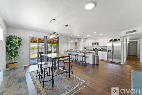 A kitchen with a dining table and chairs in the middle of the room.