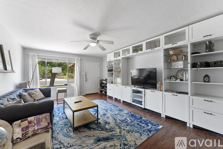 A living room with a couch, a coffee table, and a television.