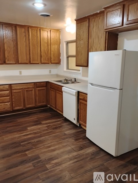 A kitchen with wooden cabinets and a white refrigerator.