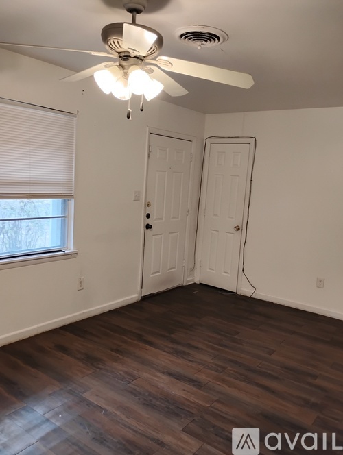 A room with a ceiling fan and two doors.