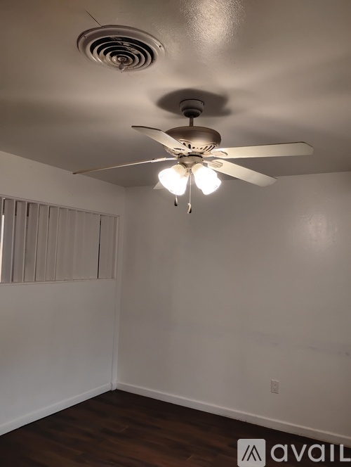 A room with a ceiling fan and a light fixture.