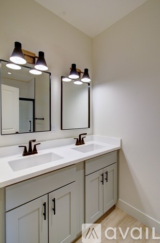 A bathroom with two sinks and two mirrors.