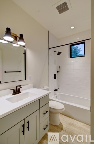 A bathroom with a sink, toilet, and tub.