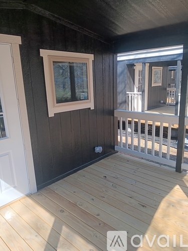 A room with wooden flooring and a window.